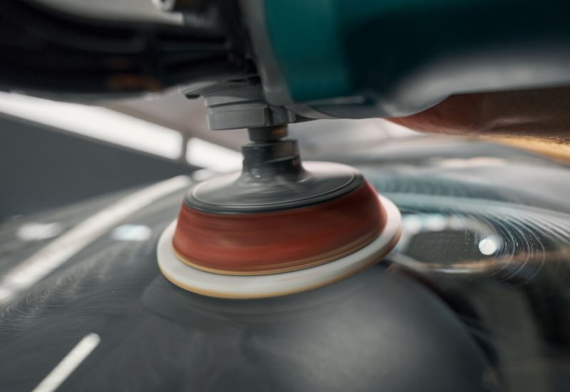 Photo of process car polishing during car detailing Close up view of polishing process with orbital polisher in car service center